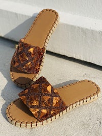 a pair of brown slide sandals on a concrete floor