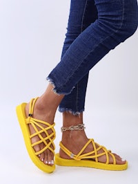 a woman wearing yellow sandals and jeans